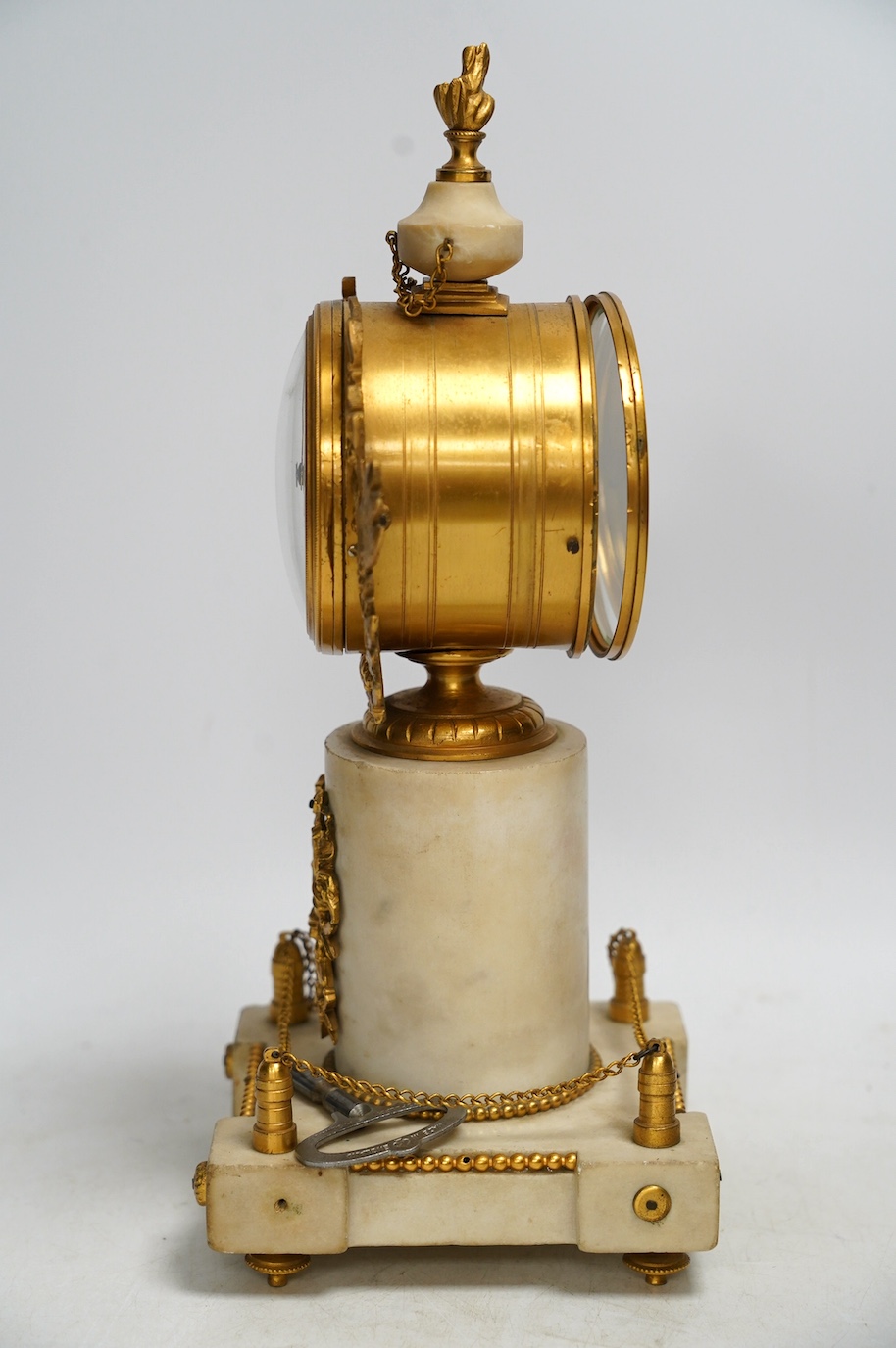 A late 19th century French alabaster and gilt metal timepiece with enamel dial, with key, 31cm high. Condition - fair